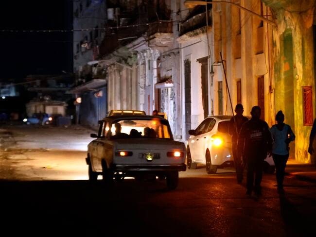 AME3506. LA HABANA (CUBA), 05/12/2024.- Personas caminan por un sector sin servicio eléctrico a causa del tercer apagón nacional este jueves, en La Habana (Cuba). El Ministerio de Energía y Minas (Minem) de Cuba anunció el restablecimiento del Sistema Eléctrico Nacional (SEN) tras el apagón nacional del miércoles, el tercero en la isla en menos de dos meses. EFE/ Ernesto Mastrascusa